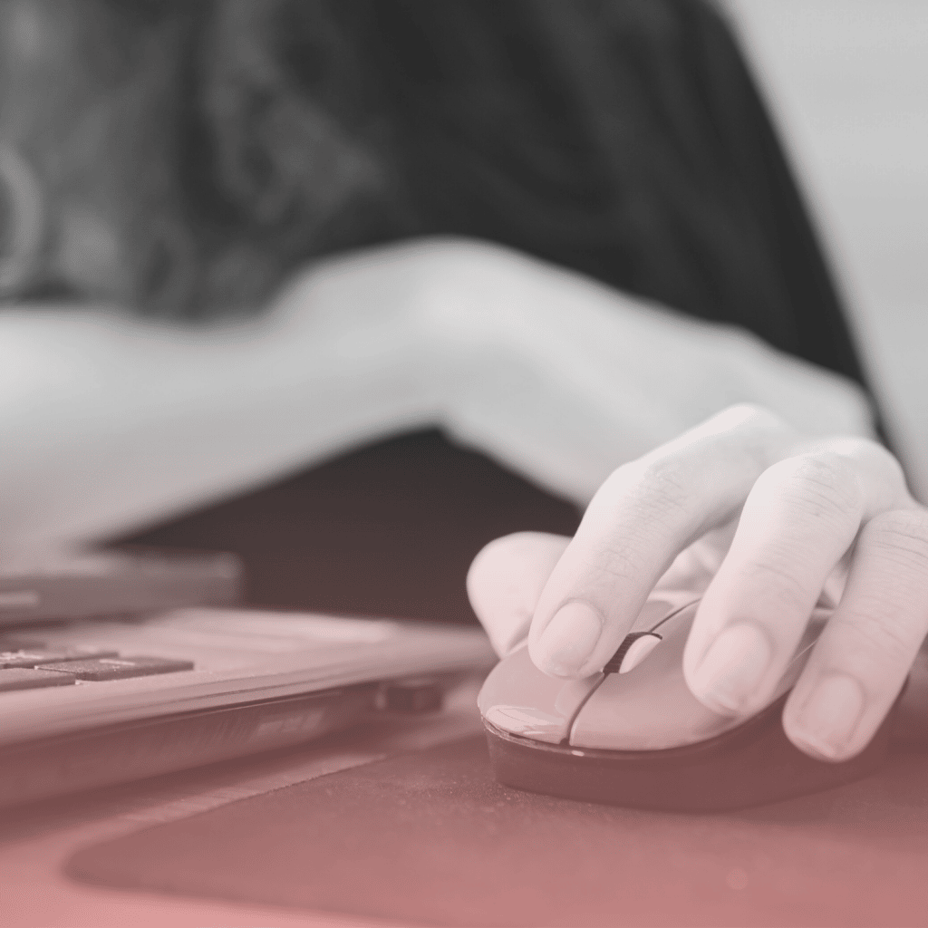 Close up of a woman holding a mouse, using a laptop